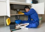 asian-plumber-blue-overalls-clearing-blockage-drain_result