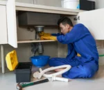 asian-plumber-blue-overalls-clearing-blockage-drain_result